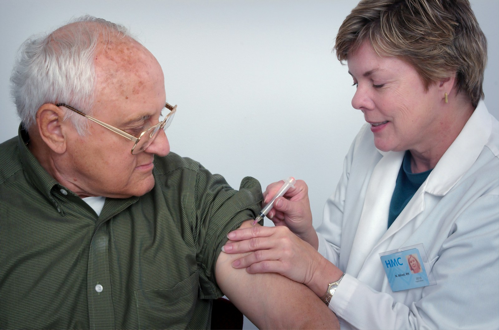 woman injecting syringe on mans arm, health